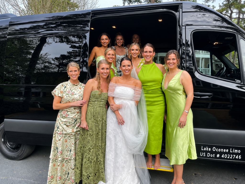 Group of women standing beside a luxury passenger van